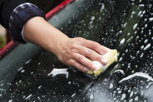 Junge Frau wäscht ein Auto — Stockfoto