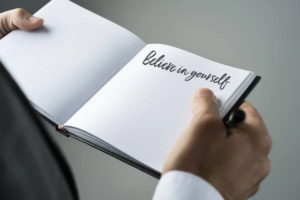 Homem e caderno com o texto acreditam em si mesmo — Fotografia de Stock