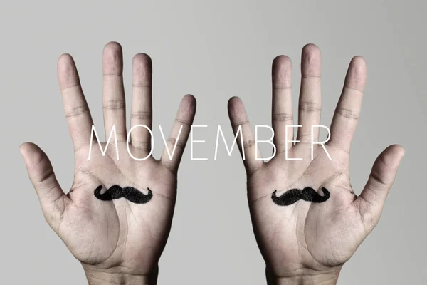 Bigode em mãos de homem e texto movember — Fotografia de Stock