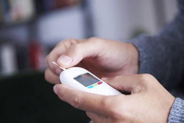 Adam kan şekeri seviyesini ölçmek üzere.