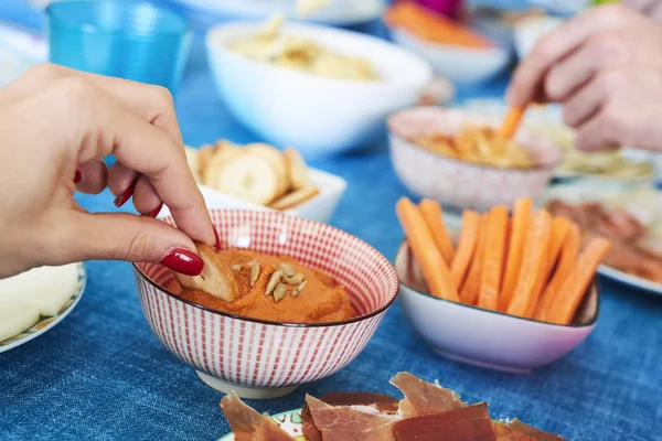 Persone che hanno alcuni antipasti su una tavola colorata — Foto Stock