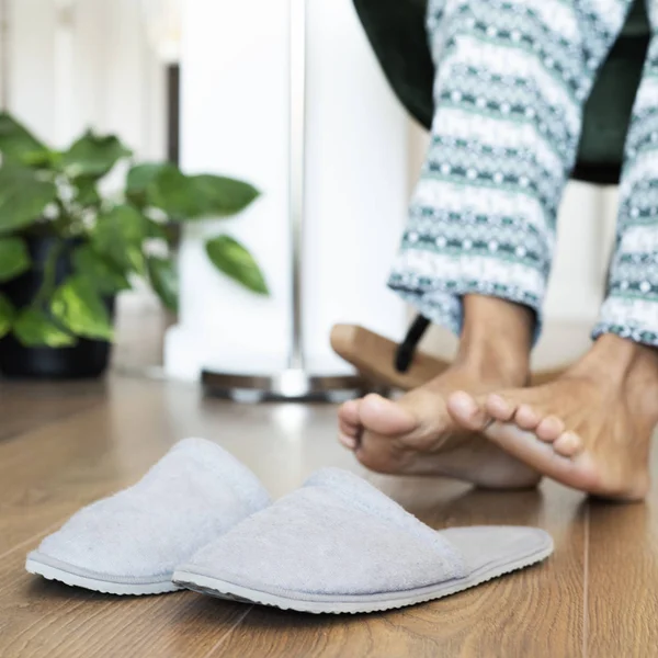 Man op het punt om zijn slipper aan te trekken — Stockfoto