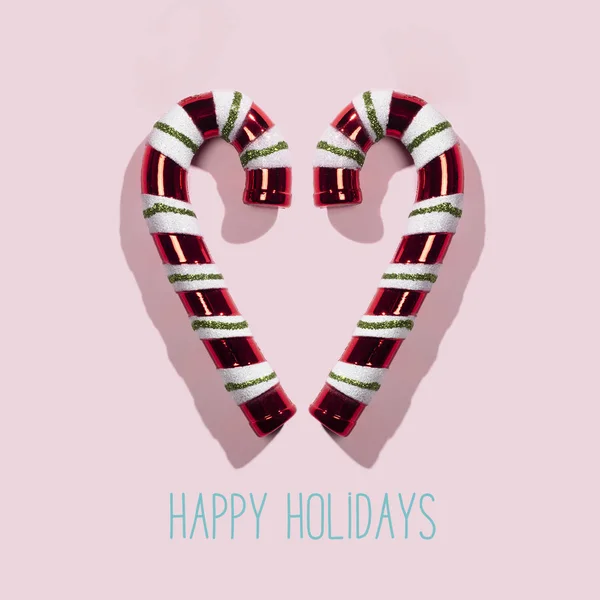 Candy canes and text happy holidays — ストック写真