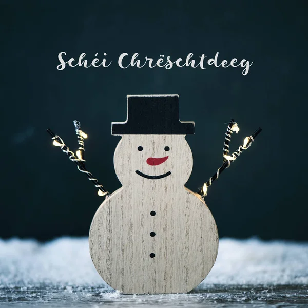 Snögubbe och text God jul i luxembourgish — Stockfoto