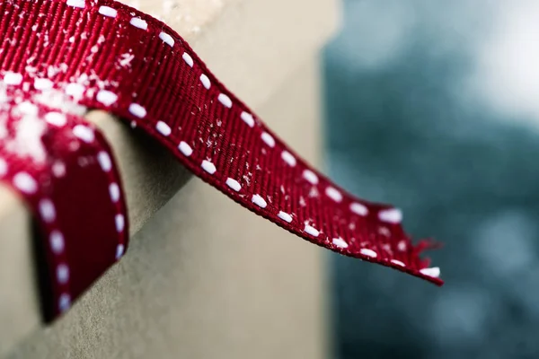 Geschenkbox gebunden mit einem schönen roten Band auf der sno — Stockfoto