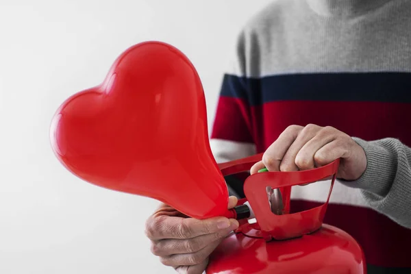 Menggembungkan balon berbentuk hati dari silinder — Stok Foto