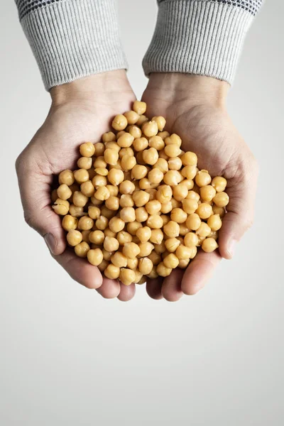 Mann mit gekochten Kichererbsen in der Hand — Stockfoto