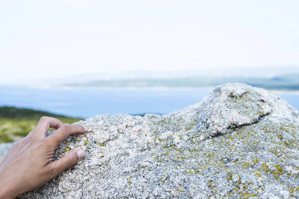 La mano de un hombre agarrando una roca al aire libre —  Fotos de Stock