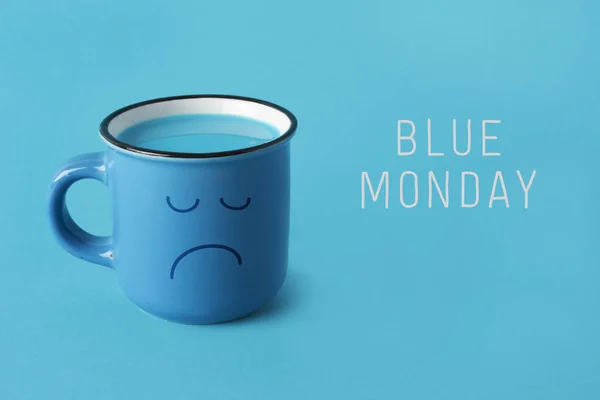 Niebieski kubek ze smutną twarzą i tekst niebieski monda — Zdjęcie stockowe