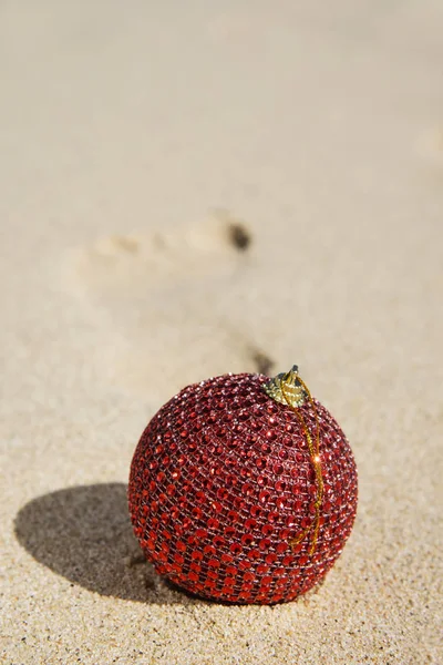 Christmas ball on the sand of the beach — Stock Photo, Image
