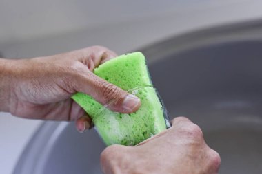 Genç adam cam yıkıyor.