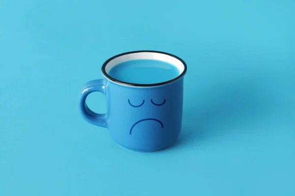 Blue mug with a sad face — Stock Photo, Image