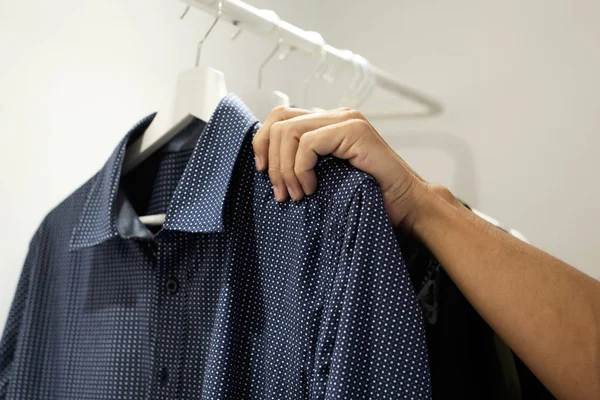 Jovem pendurado ou despendurado uma camisa — Fotografia de Stock