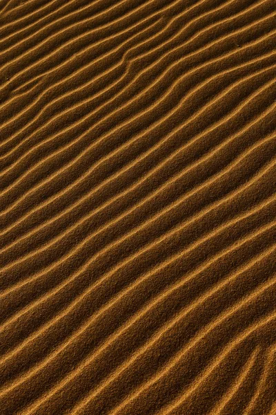 Zand achtergrond met een golvende patter — Stockfoto