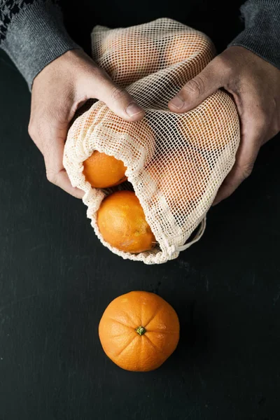 Homme et sac en maille réutilisable avec orange — Photo