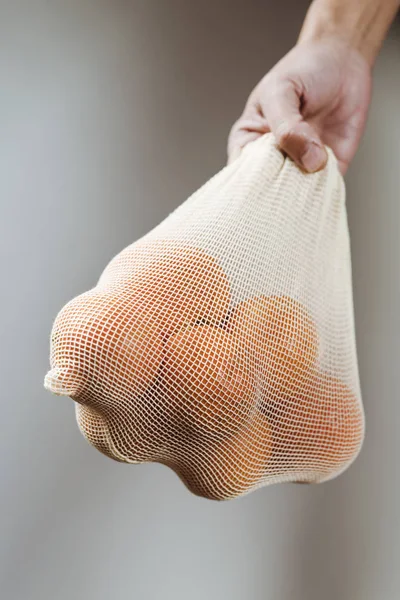 Man and reusable mesh bag with orange — Stock Photo, Image