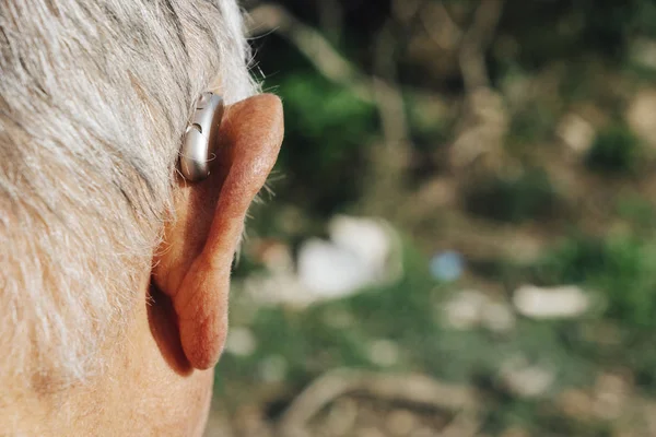 Hombre mayor que usa un audífono — Foto de Stock