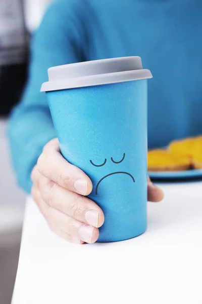 Uomo afferrando una tazza di caffè con un volto triste — Foto Stock