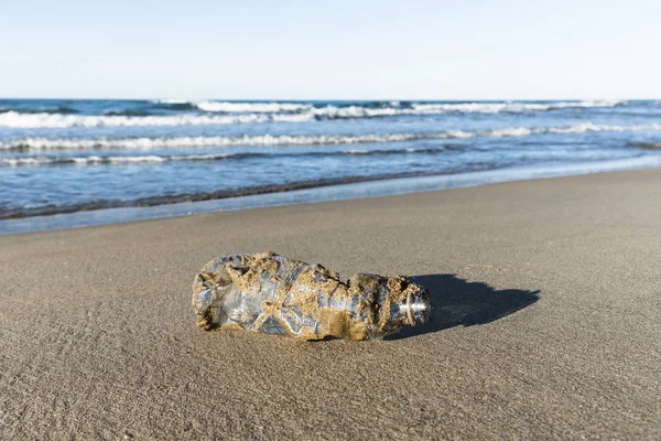 Used plastic bottle on the sand of a beach — Stock Photo, Image