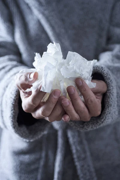 Zieke man met gebruikte weefsels in zijn handen — Stockfoto