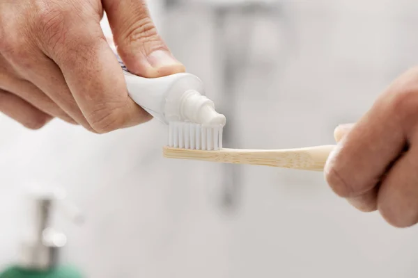 Hombre usando un cepillo de dientes de bambú en el baño —  Fotos de Stock