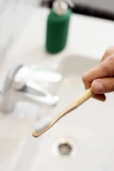 Man using a bamboo toothbrush in the bathroom — Stock Photo, Image