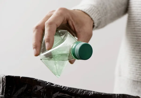 Hombre lanzando una botella de plástico a la papelera — Foto de Stock