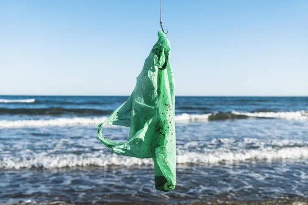Used plastic bag in a fish hook — Stock Photo, Image