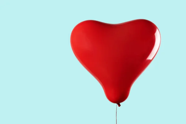 Червона повітряна куля у формі серця на синьому фоні — стокове фото