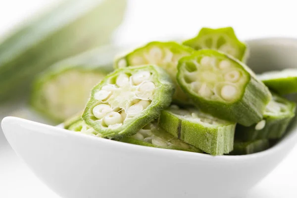 Gousses d'okra crues hachées dans un bol — Photo