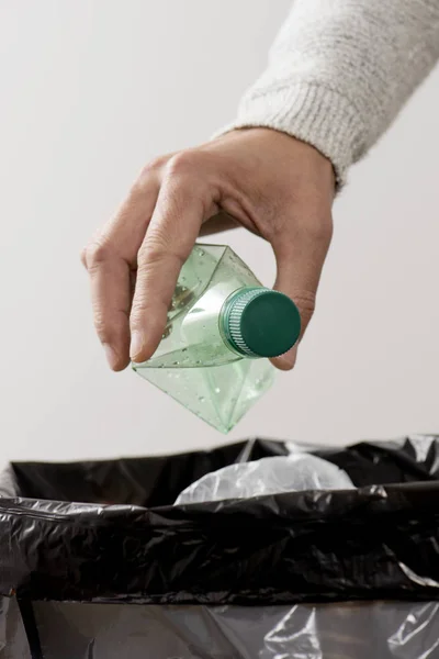 Adam çöp kutusuna plastik şişe fırlatıyor. — Stok fotoğraf