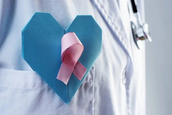 Lekarz z niebieskim sercem i różową wstążką — Zdjęcie stockowe