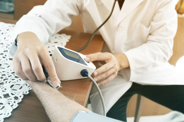 Médico que mede a pressão arterial de um idoso — Fotografia de Stock