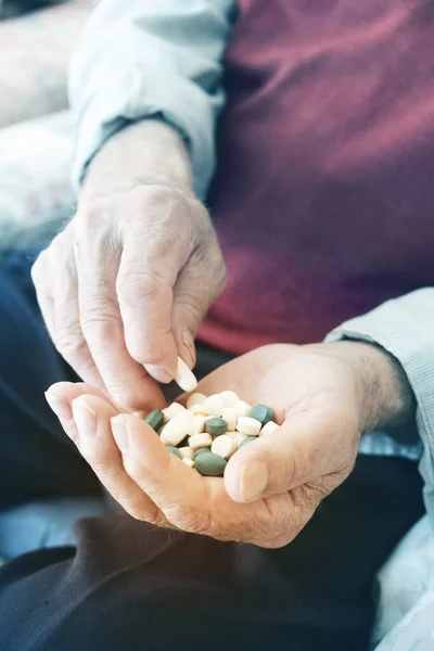 Senior mit einem Stapel Pillen in der Hand — Stockfoto