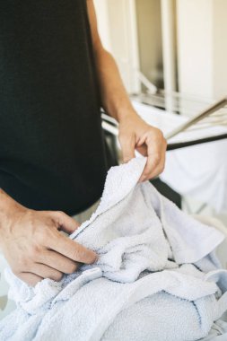 bir kurutma rac üzerinde giysi asılı adam