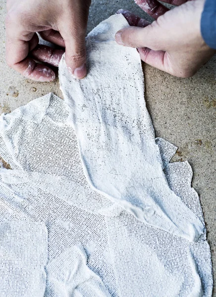 Man working with fabric soaked in wet plaster — Stockfoto