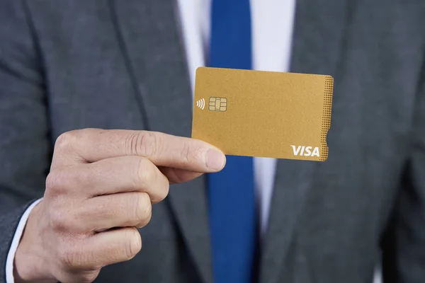 Geschäftsmann zeigt eine goldene Visa-Kreditkarte — Stockfoto