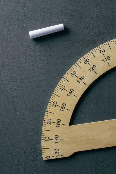 Protractor and piece of chalk on a chalkboard — 스톡 사진