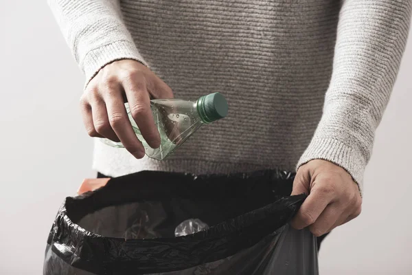 Homme jetant une bouteille en plastique à la poubelle — Photo