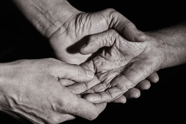 セピアのトーンで愛情を持つ古い白人女性の手を握っている若い白人男性の閉鎖 — ストック写真