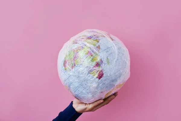 Man Holds World Globe Wrapped Plastic Depicting Plastic Contamination Protection — Stock Photo, Image