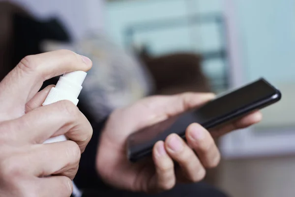 Primer Plano Hombre Caucásico Desinfectando Teléfono Inteligente Pulverizando Desinfectante Una —  Fotos de Stock