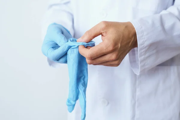 Closeupo Médico Caucásico Con Una Bata Blanca Poniéndose Par Guantes — Foto de Stock