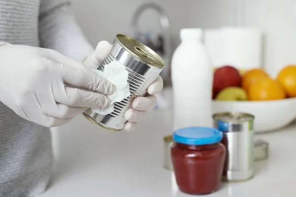 厨房里一个戴着乳胶手套的男人的特写镜头 用消毒剂擦拭新近购买的食品罐和罐子 — 图库照片