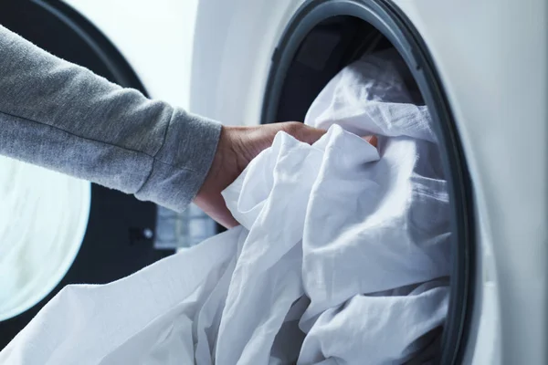 Closeup Young Caucasian Man Putting White Bed Linen Washing Machine — Stock Photo, Image