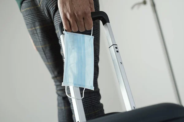 Closeup Young Man Surgical Mask His Hand Pulling Suitcase Its — Stock Photo, Image