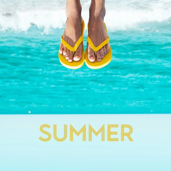 ビーチの若い白人男性の足を閉じて 逆さまにして 黄色のフリップフロップのペアを着て 下のテキスト夏 — ストック写真