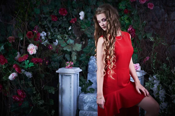 Märchen. schöne Prinzessin im roten Kleid sitzt in einem mystischen Garten — Stockfoto