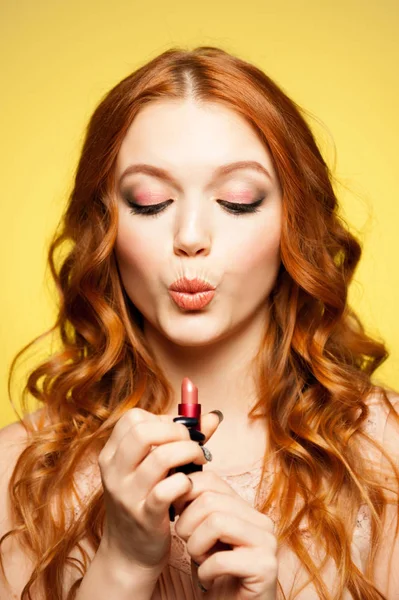 Young redhead woman holding lipstick — Stock Photo, Image