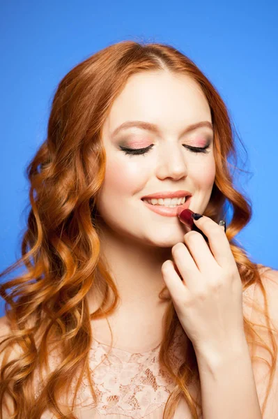 립스틱을 들고 있는 젊은 빨간 머리 여자 — 스톡 사진